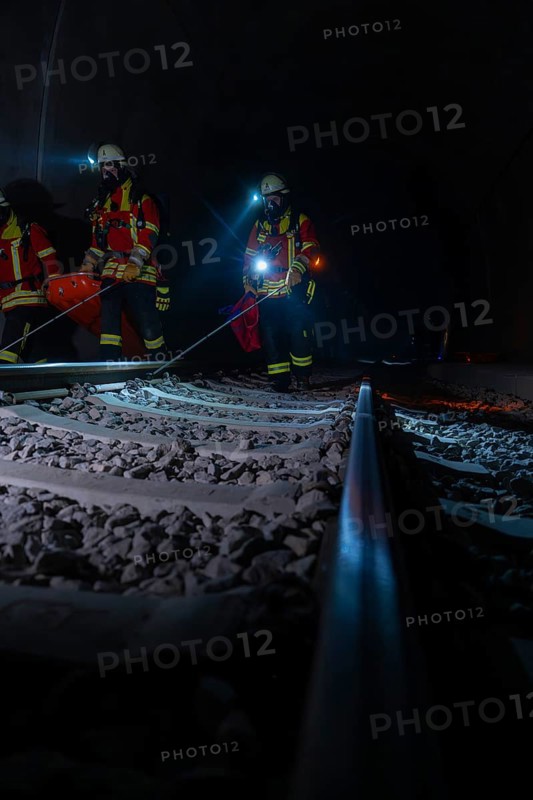 Rescue workers in the tunnel on railway tracks in the dark with blue lights, fire brigade exercise in the new tunnel of the Hermann Hessebahn, Ostelsheim, Calw district, Germany