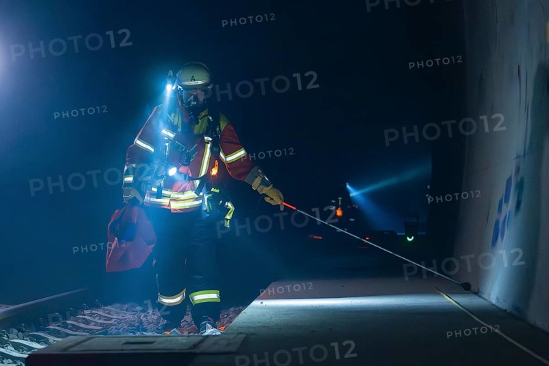 Fireman on a railway platform, at work in the evening with a torch, fire drill in the new construction tunnel of the Hermann Hessebahn, Ostelsheim, district of Calw, Germany