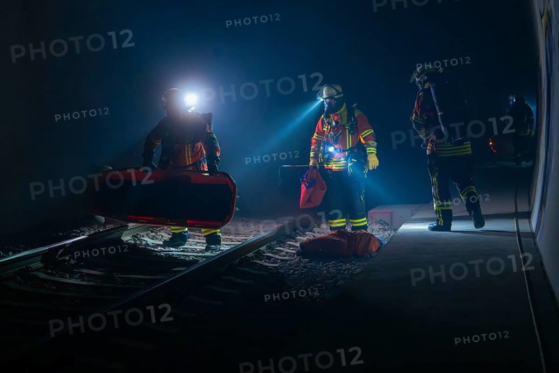 Group of firefighters during a night-time operation on the tracks, firefighting exercise in the new construction tunnel of the Hermann Hesse railway, Ostelsheim, Calw district, Germany