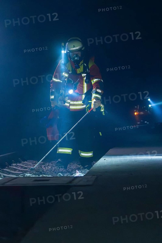 Firefighter examining railway track with lantern in a dark environment, firefighting exercise in the new construction tunnel of the Hermann Hessebahn, Ostelsheim, Calw district, Germany