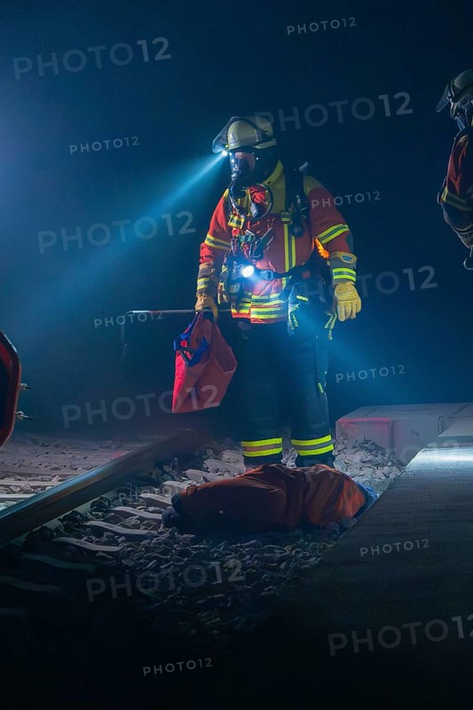 Fireman illuminates the tracks with a torch, nocturnal atmosphere, fire drill in the new tunnel of the Hermann Hesse railway, Ostelsheim, district of Calw, Germany