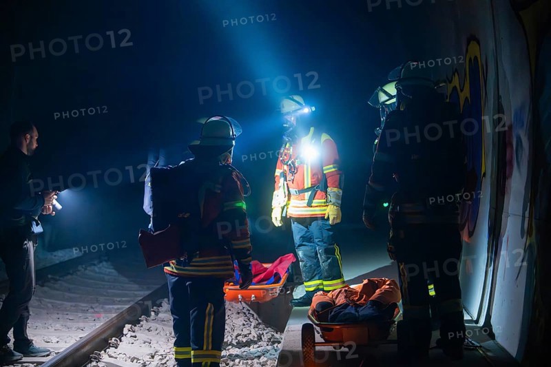Group of firefighters ready for action on railway tracks at night, firefighting exercise in the new construction tunnel of the Hermann Hesse railway, Ostelsheim, Calw district, Germany