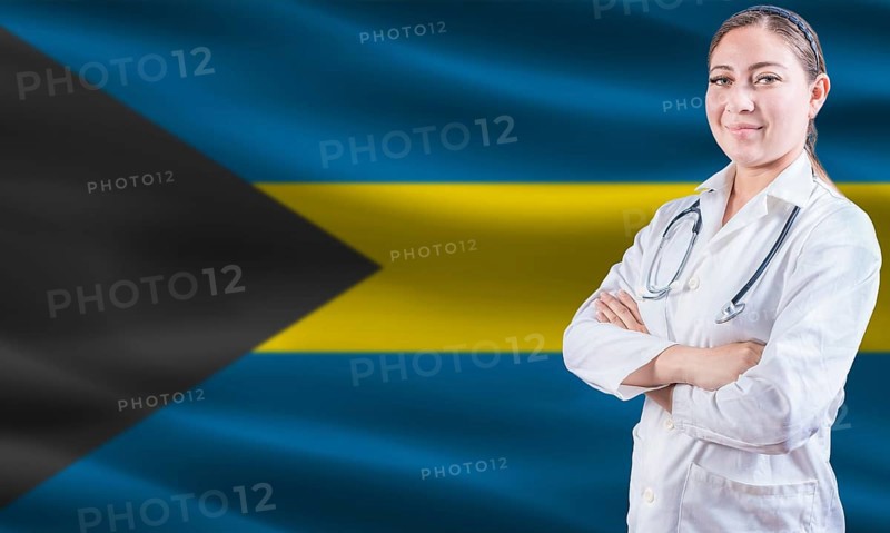Female doctor on Bahamas flag. Doctor with crossed arms on Bahamas flag. Bahamas health and care concept