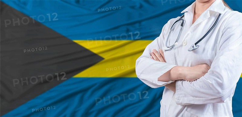 Doctor with crossed arms on Bahamas flag. Bahamas health and care concept. Female doctor on Bahamas flag