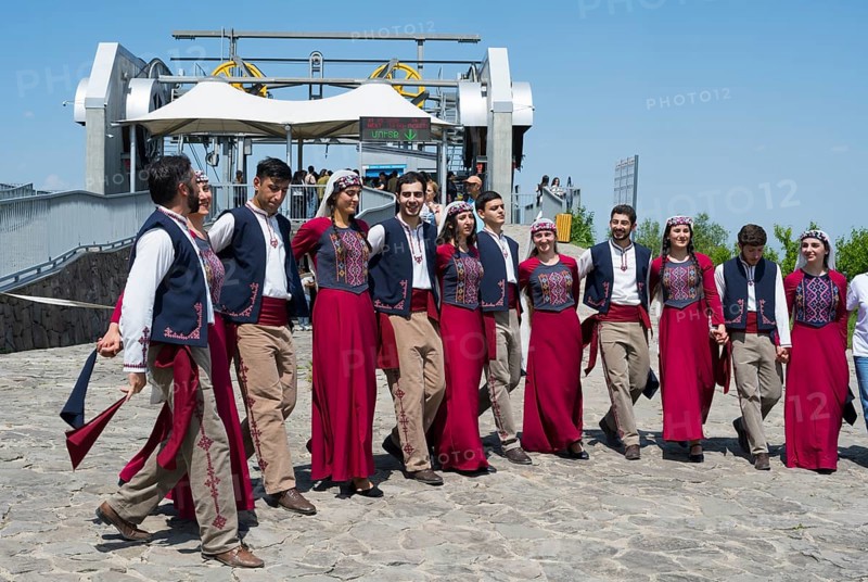 Group performing traditional dance on paved area in sunny weather, folklore, Tatev, Tatev, Syunik province, Syunik, Armenia