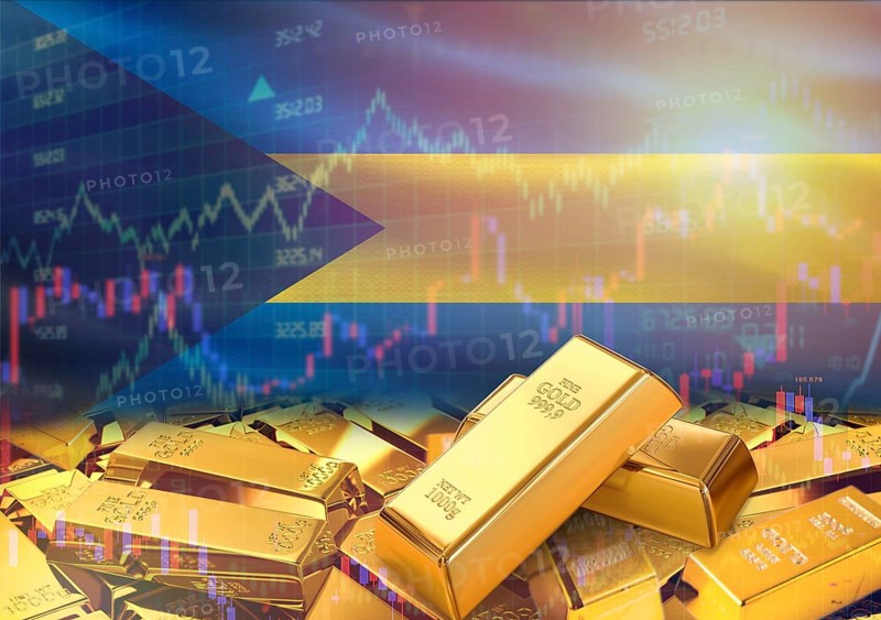 Gold bars on Bahamas flag in background. Gold bars stacked on Bahamian flag. Concept of Bahamas gold reserves