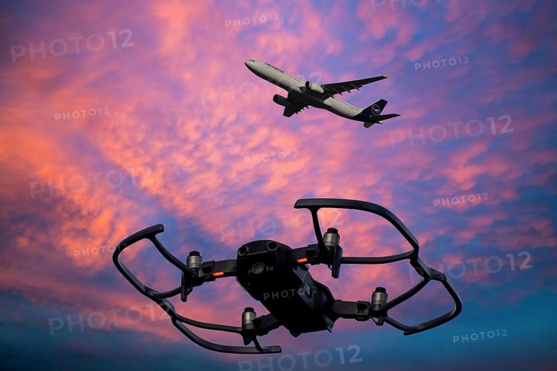 (Photomontage) Close-up of a drone in the evening sky, a Lufthansa aircraft in the background