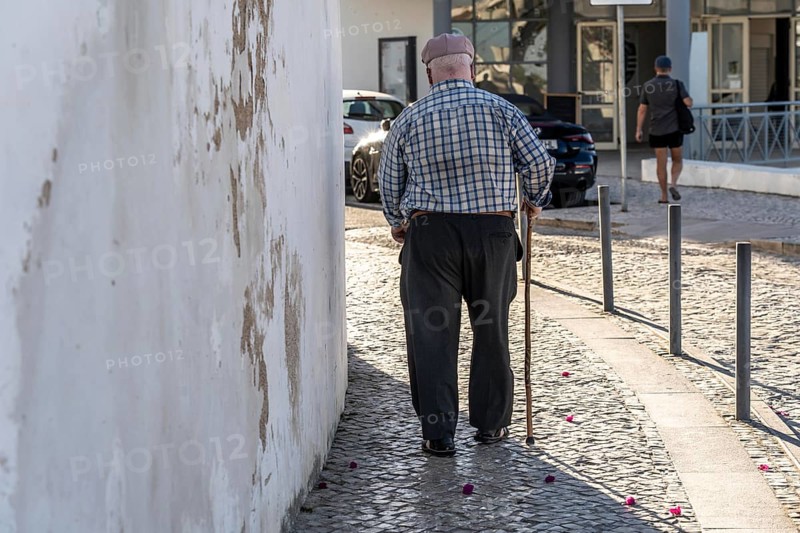 Elderly man with walking stick, in the historic centre of Lagos, Algarve, Portugal