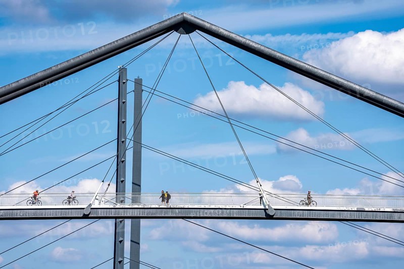 Bridges in Düsseldorf, in the foreground, the pedestrian and cycle bridge over the canal to the inner harbour, media harbour of Düsseldorf, behind it the Rheinkniebrücke, road bridge over the Rhine near Düsseldorf, Germany