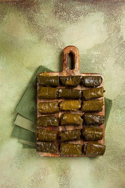 Dolma, minced meat with rice, in grape leaves, minced meat rolls, on a chopping board, top view, no people