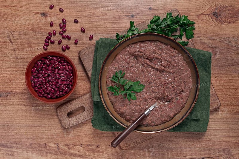 Red bean lobio, a traditional Georgian dish, on a wooden table, homemade