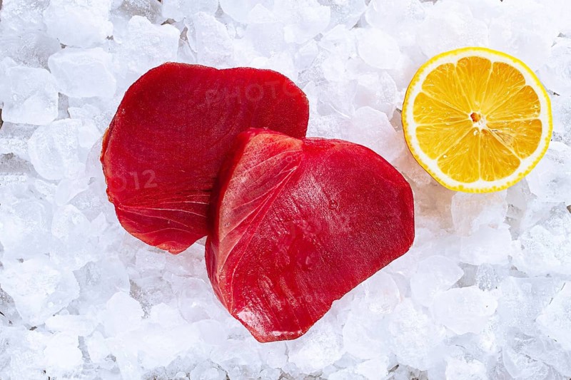 Fresh tuna and lemon, on ice ready, for preparation, at a seafood market