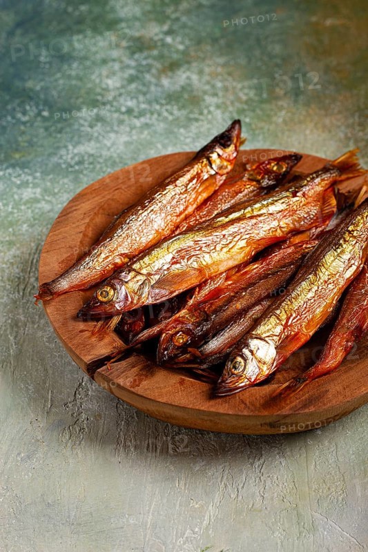 Cold smoked capelin, on a wooden bowl, top view, no people