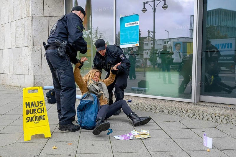 New generation raids the Konrad Adenauer House, the federal headquarters of the CDU, on suspicion of corruption. Police arrest activist. Warning sign with house search. A New Generation poster with #Merzmafia / Return of the #Klimakleber is stuck to the building. Fake banknotes scattered on the floor. Berlin, 06.10.2025