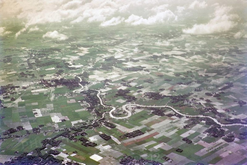 Captioned as 'aerial photo Saigon', meandering river in flat agricultural landscape of paddy fields, Vietnam, south east Asia c 1964