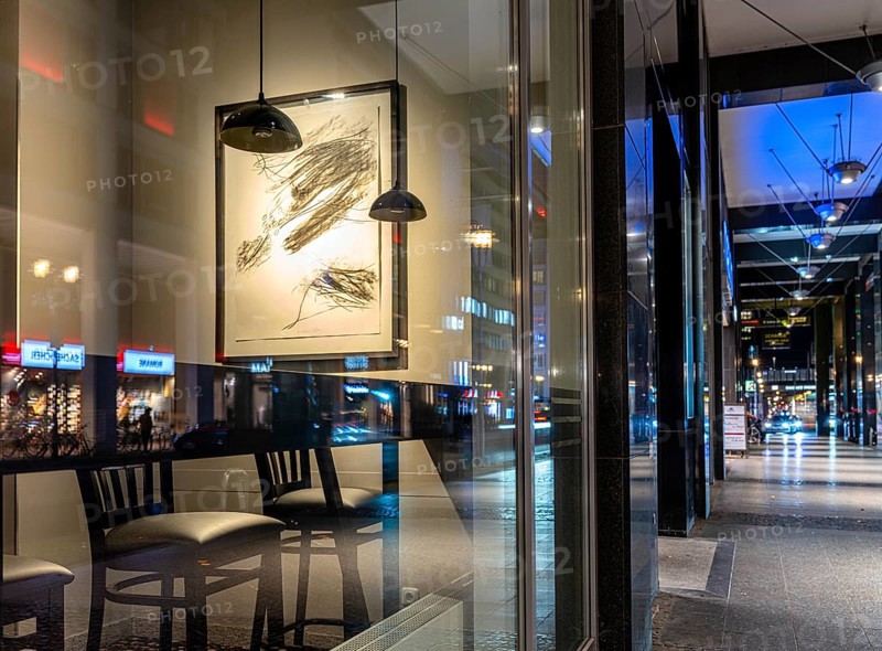 Urban scene in the evening with reflections of Friedrichstraße in the window pane of a bistro, Berlin, Germany