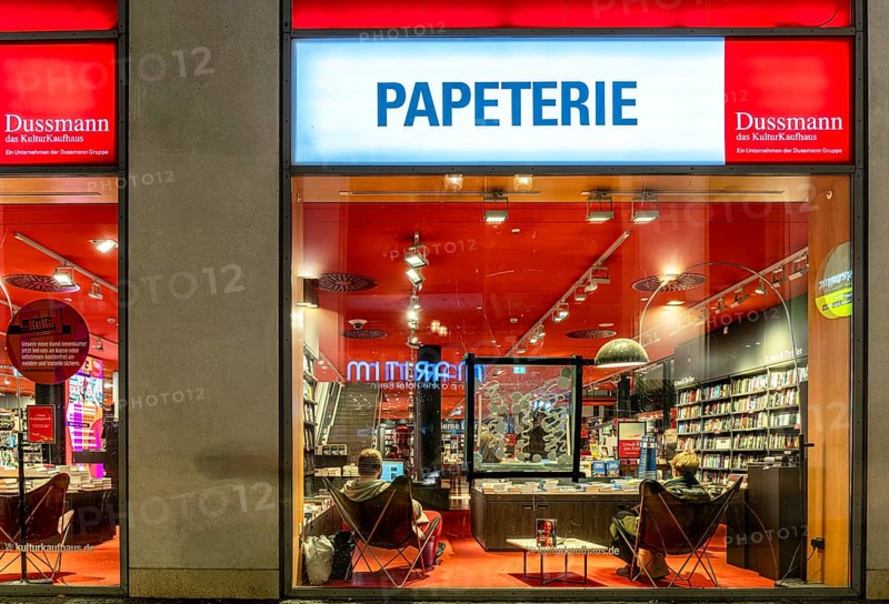Dussmann GmbH, Bookstore, Urban scene in the evening with reflections in the window pane and a view of the displays and shelves, Berlin, Germany