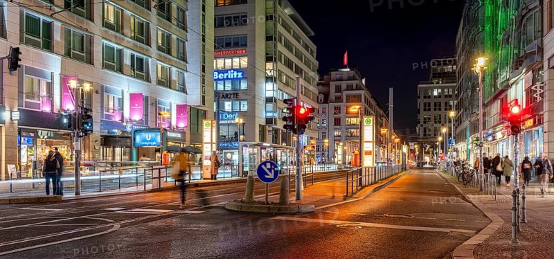 Night shot of Friedrichstraße at the railway station with a view of the tram stop and the commercial buildings along the pavements, Berlin, Germany