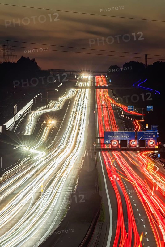 Motorway near Stuttgart with several lanes in the evening with sunset. Heavy traffic with light lanes. BAB 8 motorway near Wendlingen, Baden-Württemberg, Germany