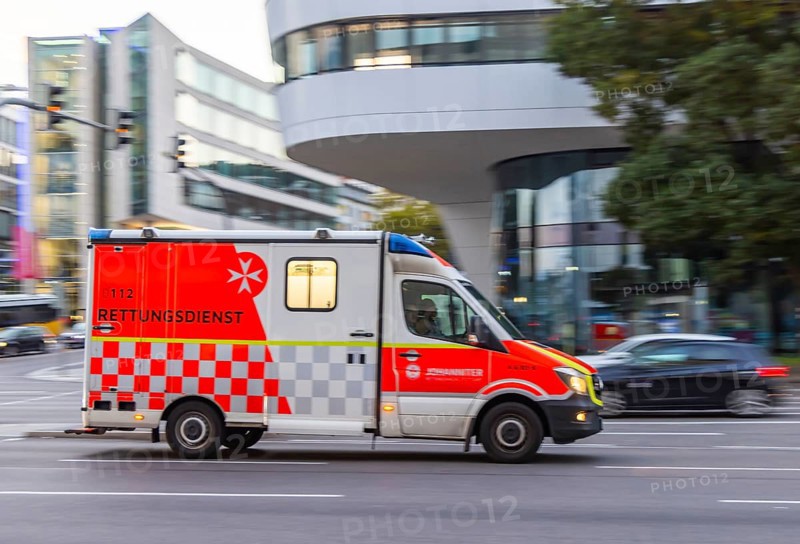 Ambulance of the BOS organisation Johanniter in an urban environment. Pull along. Stuttgart, Baden-Württemberg, Germany