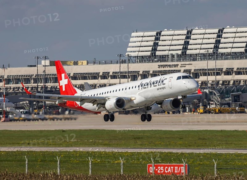 Flight operations at Stuttgart Airport with terminal. Aircraft on landing. Aircraft registration number: HB-JVZ, Helvetic Airways, Embraer ERJ-195, Stuttgart, Baden-Württemberg, Germany