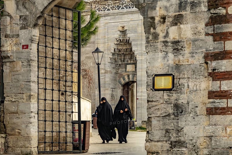 Women veiled in black with niqab at the Fatih Mosque in Fatih, Istanbul, Turkey