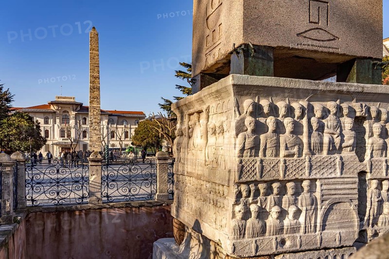 Marble base of the ancient Egyptian Obelisk of Theodosius or Obelisk of Istanbul with reliefs and the Column of Constantine or Masonry Obelisk at the Hippodrome in Istanbul, Turkey