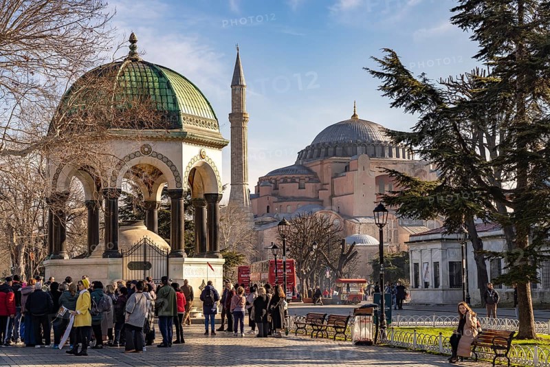 Tourists at the German Fountain or Kaiser Wilhelm Fountain and the Hagia Sophia or Church of St Sophia, former Byzantine church and museum in Istanbul, Turkey