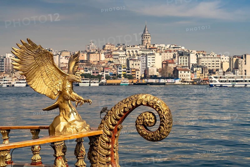 Golden oriental restaurant ship on the banks of Eminönü, Beyoglu and the Galata Tower, Istanbul, Turkey