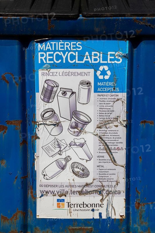 Close-up of accepted recyclable materials list on blue metal with black plastic lid industrial size recycling bin, Ile des Moulins, Old Terrebonne, Quebec, Canada