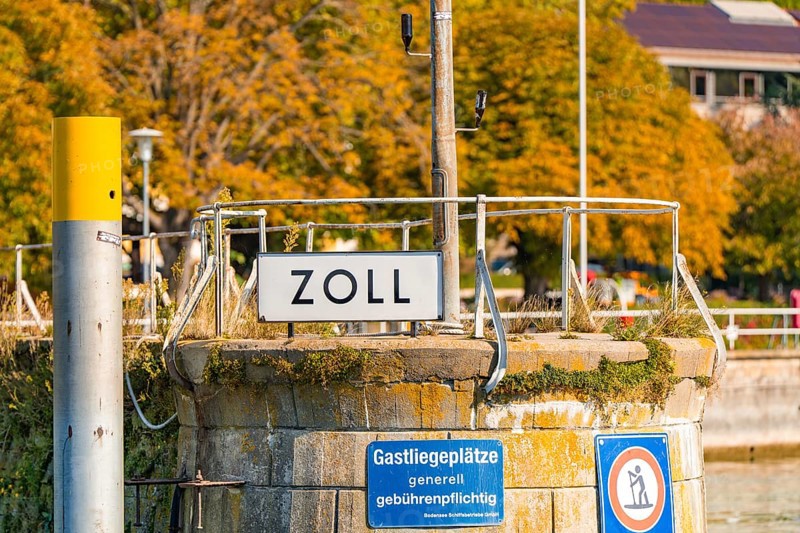 Small customs station on the shore with railings and signs in autumnal surroundings, Meersburg, Lake Constance, Germany