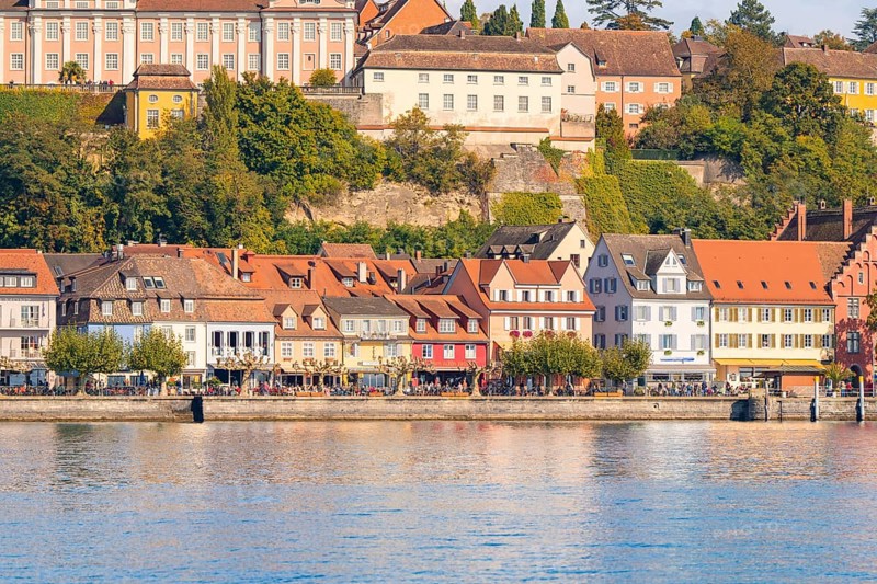 Historic row of houses on the lake with colourful architecture and autumnal trees, Meersburg, Lake Constance, Germany