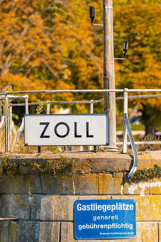 Close-up of a customs sign with autumn leaves in the background, Meersburg, Lake Constance, Germany