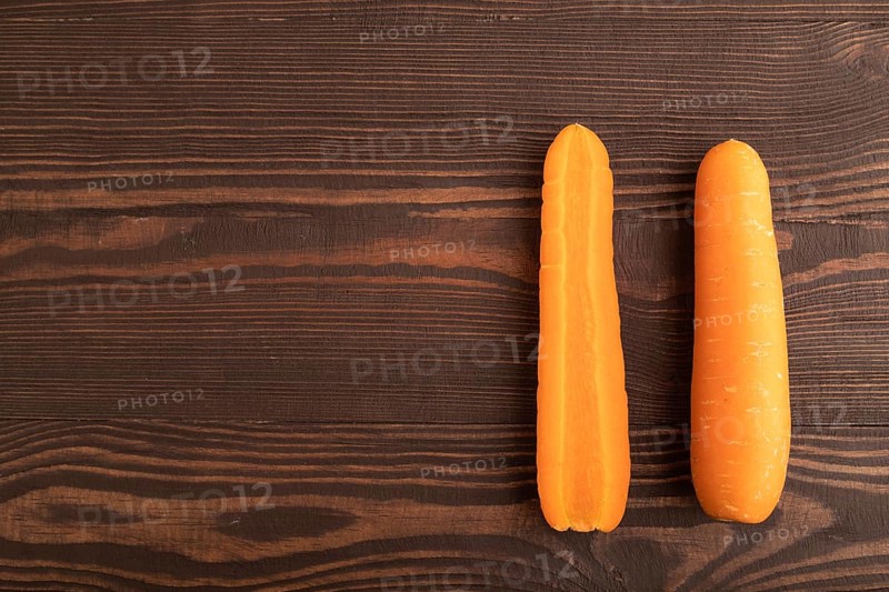 Orange Carrot on brown wooden background. Top view, copy space, flat lay. healthy food, vegetable, minimalism