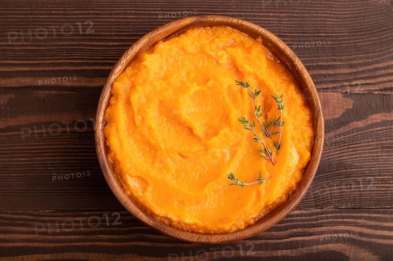 Sweet potato porridge in wooden bowl on wooden background. Diet, healthy eating concept. top view, flat lay, close up, minimalism
