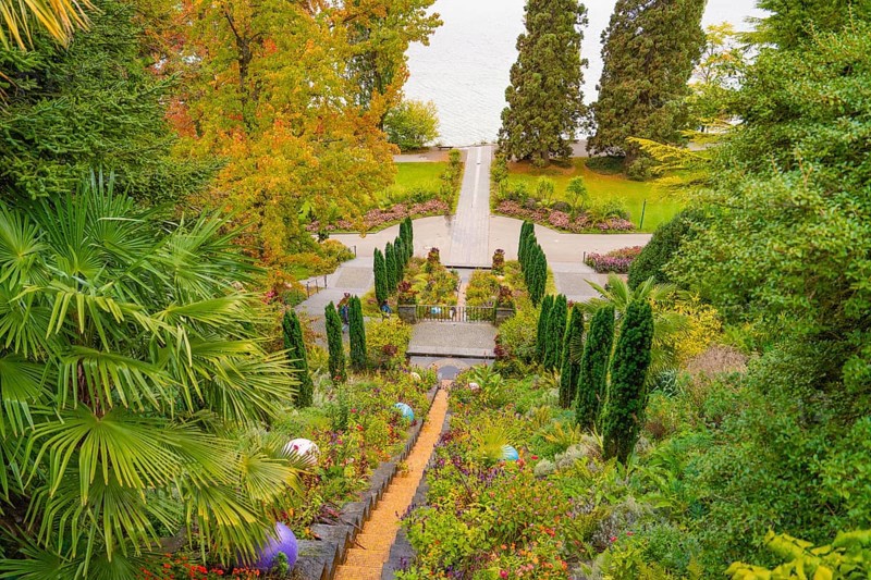 Well-tended garden with steps, lined with flowering plants in autumnal colours, Mainau Island, Lake Constance, Germany
