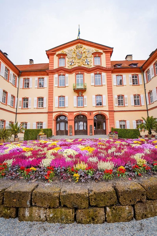 Symmetrical palace view with magnificent, colourful flowers, Mainau flower island, Lake Constance, Germany