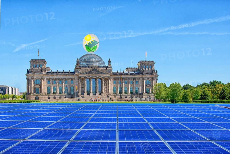 Symbolic image, solar park in the city, Reichstag building Berlin with environmental logo, modules on the green area, fictitious example photo, sensible use of space, renewable energy, green energy, hydropower, wind power, solar energy, solar power, photovoltaics, climate change, climate protection, CO2 emissions, ecology, greenhouse gases, Germany