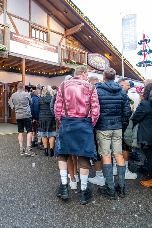 Group of people in traditional Bavarian traditional costume in front of a venue, Cannstatter Wasen folk festival, Stuttgart, Germany