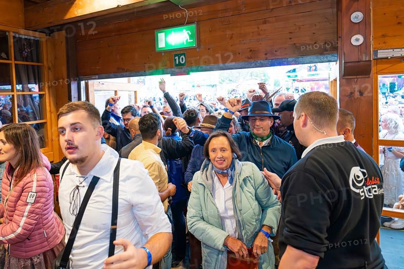 People in traditional traditional costume standing at the entrance to the marquee, lively atmosphere, Cannstatter Wasen folk festival, Stuttgart, Germany