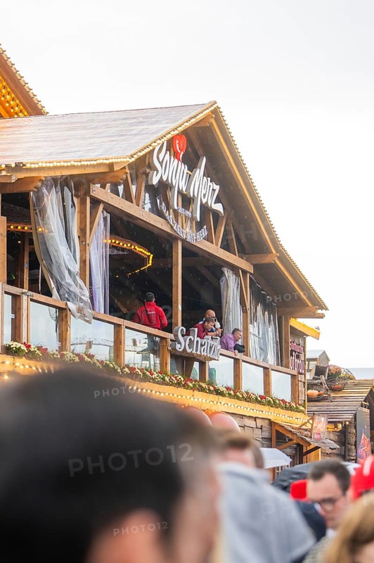People standing on a balcony of a Bavarian wooden building with a glass front, Cannstatter Wasen folk festival, Stuttgart, Germany