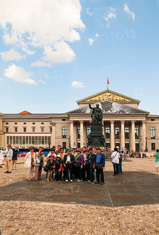 Japanese tourist group in front of the King Max I Joseph Monument. In the back National Theatre Bavarian State Opera, on the left Residenztheater, Munich, Bavaria