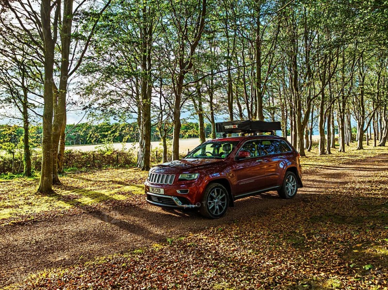 4x4 car with roof tent on autumn forest road, Tyninghame House, River Tyne, East Lothian, Scotland, UK