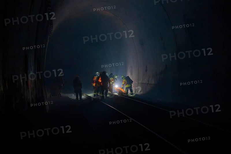Firefighters at work in a dark tunnel on tracks, firefighting exercise in the new construction tunnel of the Hermann Hesse railway, Ostelsheim, Calw district, Germany