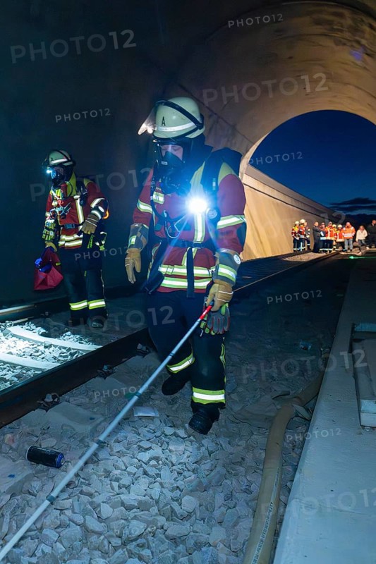 Firefighters with equipment walk along tracks in a tunnel, firefighting exercise in the new tunnel of the Hermann Hessebahn railway, Ostelsheim, Calw district, Germany