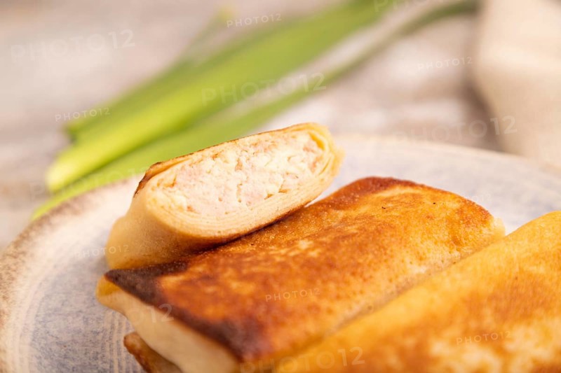 Fried crispy pancakes with meat and cheese on brown concrete background and linen textile. side view, close up, selective focus