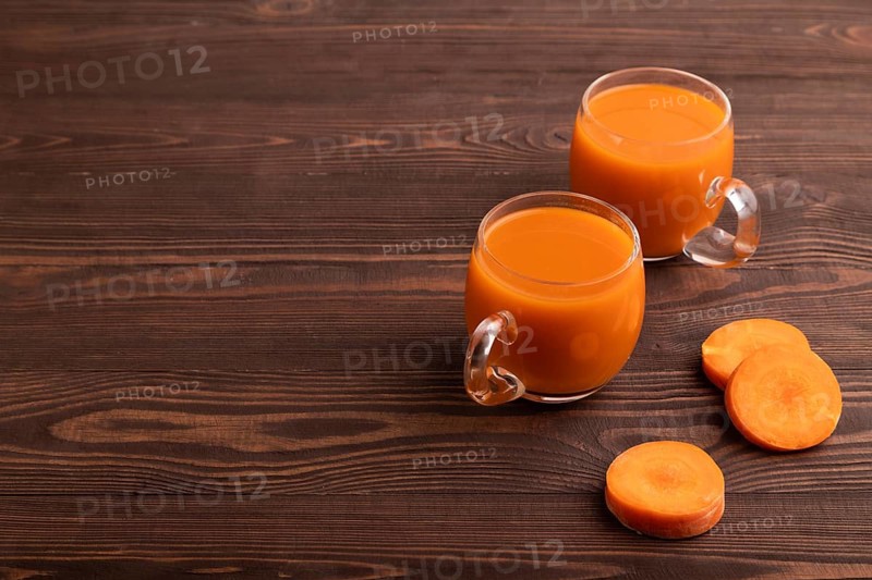 Two glasses with carrot juice, on wooden background. Diet, healthy eating concept. side view, copy space, minimalism