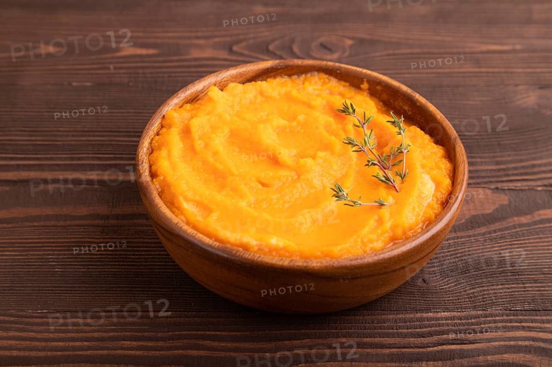 Sweet potato porridge in wooden bowl on wooden background. Diet, healthy eating concept. side view, close up, minimalism
