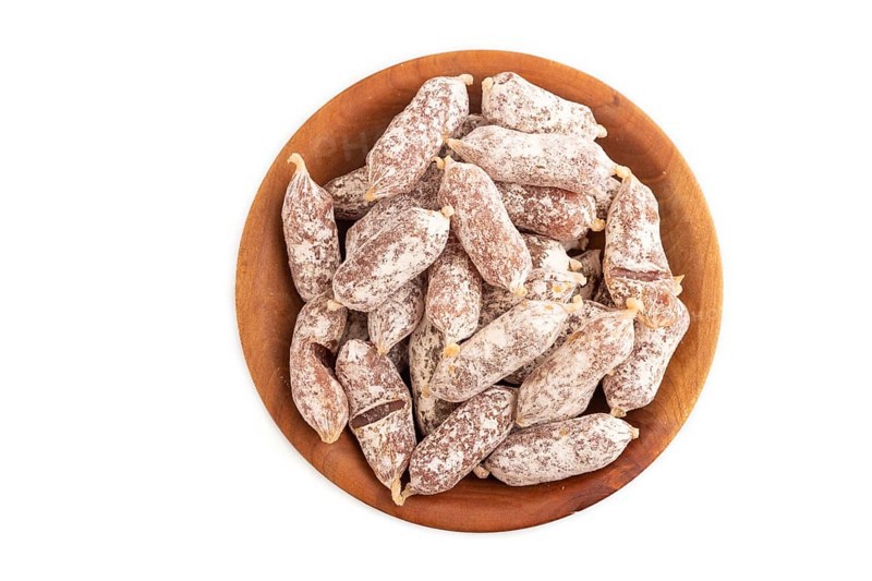 Small smoked Chicken sausages in wooden bowl isolated on white background. top view, close up