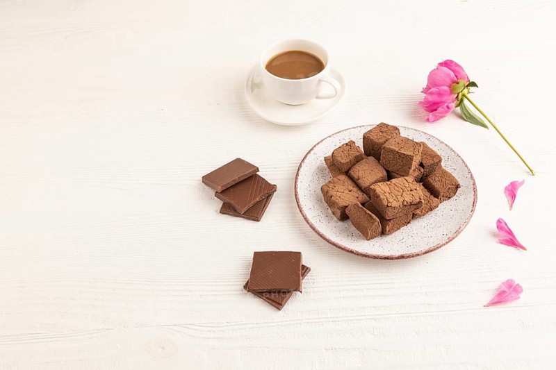 Chocolate marshmallow with cup of coffee on white wooden background. side view, copy space